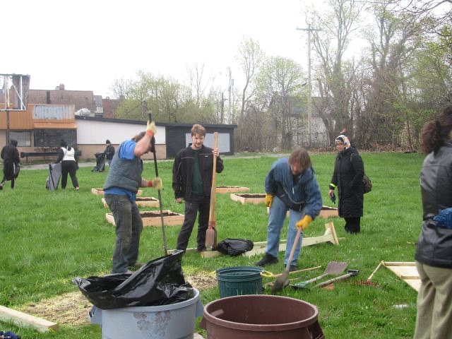 Volunteers work on setting up a bulletin board and setting garden boxes.